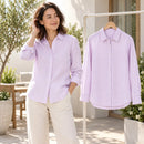 Una mujer usa una camisa de rayas lila y blanco; otra camisa completa cuelga al lado
