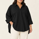 Camisa negra amplia con cuello clásico y frente discreto